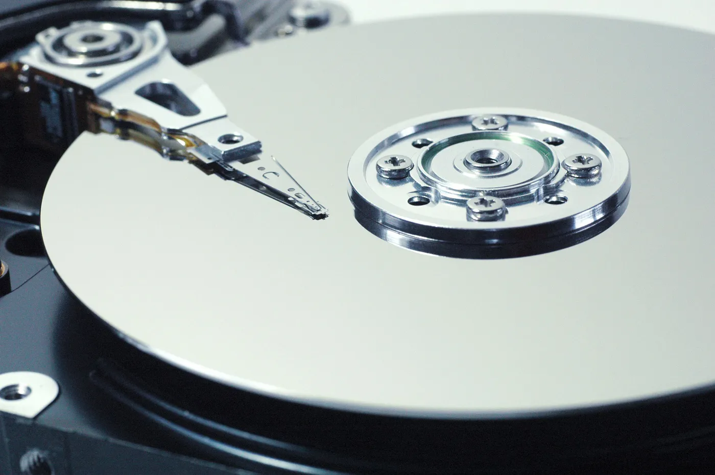 The mirrored platter and read/write arm inside an opened hard drive